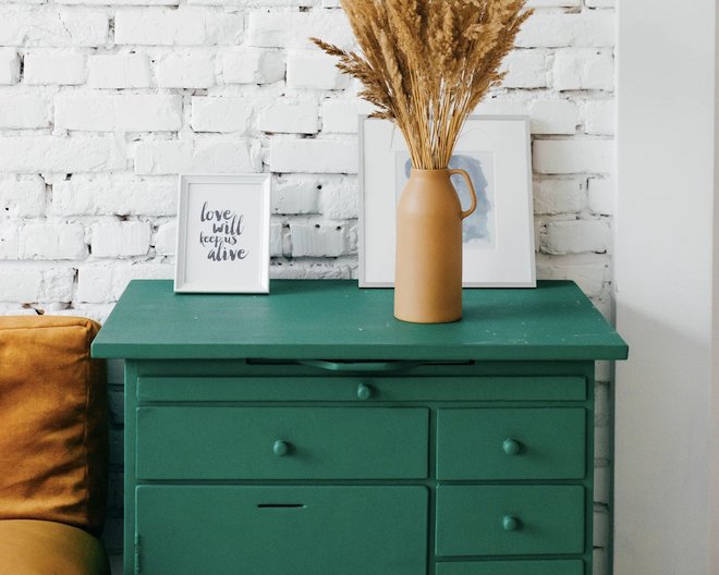 green drawers with a yellow vase and photo frames